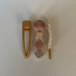 Style your hair with these beautiful trio of hair clips. It is the perfect accessory to any outfit! Plain gold clip; dusty rose and champagne clip; and a simulated pearl pin. Can be worn each as a single clip or pin or stacked together. You can also mix and match with another favourite clip of yours!  Three pieces