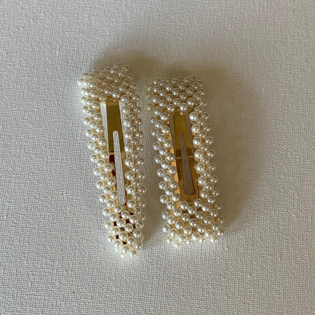 Style your hair with these beautiful duo simulated pearl hair clips. They are the perfect accessory to any outfit! These clips can be worn each as a single clip or together. You can also mix and match with another favourite clip of yours!  Two pieces 