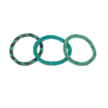 Load image into Gallery viewer, These &quot;Miami Jade Roll Ons&quot; come as a set of three.  They are handmade with love by women artisans in Nepal, using high quality glass beads and hand-dyed cotton thread. These bracelets will expand over your hand to fit most wrist.   The purchase of these bracelets empowers female artisans through fair trade.Your purchase provides women with fair income + benefits in a safe and healthy work environment. Aid Through Trade empowers women by creating opportunity through beautifully designed jewelry.
