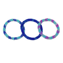 Load image into Gallery viewer, These &quot;Sea Fantasy Roll Ons&quot; come as a set of three.  They are handmade with love by women artisans in Nepal, using high quality glass beads and hand-dyed cotton thread. These bracelets will expand over your hand to fit most wrist.   The purchase of these bracelets empowers female artisans through fair trade. Your purchase provides women with fair income + benefits in a safe and healthy work environment. Aid Through Trade empowers women by creating opportunity through beautifully designed jewelry.
