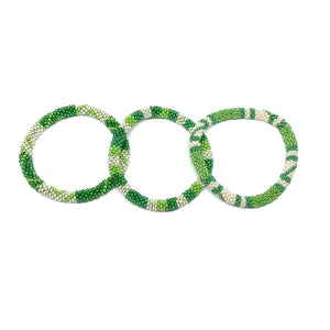 These "Green Gecko Roll Ons" come as a set of three.  They are handmade with love by women artisans in Nepal, using high quality glass beads and hand-dyed cotton thread. These bracelets will expand over your hand to fit most wrist.   The purchase of these bracelets empowers female artisans through fair trade. Your purchase provides women with fair income + benefits in a safe and healthy work environment. Aid Through Trade empowers women by creating opportunity through beautifully designed jewelry.