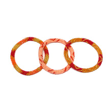 Load image into Gallery viewer, These &quot;Peach Darling Roll Ons&quot; come as a set of three.  They are handmade with love by women artisans in Nepal, using high quality glass beads and hand-dyed cotton thread. These bracelets will expand over your hand to fit most wrist.   The purchase of these bracelets empowers female artisans through fair trade. Your purchase provides women with fair income + benefits in a safe and healthy work environment. Aid Through Trade empowers women by creating opportunity through beautifully designed jewelry.
