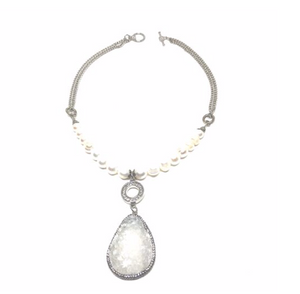 This genuine freshwater pearl necklace has a genuine druzy gemstone pendant which is surrounded by beautiful czech crystals  The charms and finishings are all white gold plated.  Necklace is lead, nickel free and tarnish resistant  This necklace is 18" in length with a toggle clasp and is rhodium plated  Druzy Stone is approx. 1.5" x 2"  Designed and handcrafted by Canadian artisan