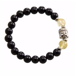 Stretchable bracelet with two citrine beads surrounding a Buddha charm. Accented with black onyx beads.As a healing stone, black onyx is thought to increase regeneration, happiness, intuition and instincts.  Includes:  1 bracelet, 18 cm in circumference with stretch cord, 9 mm beads 