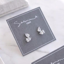 Load image into Gallery viewer, These Sourire stud earrings have a unique design, featuring two stacked teardrop crystals. Elegant and beautiful, these earrings are perfect for adding to your everyday look.   Main material: 16k Gold/ Rose Gold/ Rhodium Plated, Brass, .925 Sterling Silver Post  Lead and Nickel Free  Charm 9mm x 13mm 
