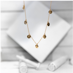 A classic multi-charm design that sits slightly looser than a choker, and is adjustable to fit various neck sizes. Each charm is stamped on both sides with B&U markings.  This necklace is gold plated stainless steel with a lobster clasp.   Length: 18” 